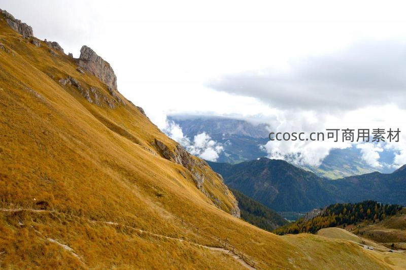秋日金黄山坡与云中远山画卷