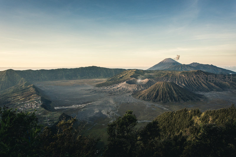火山群在晨曦中喷发烟雾的壮观景象
