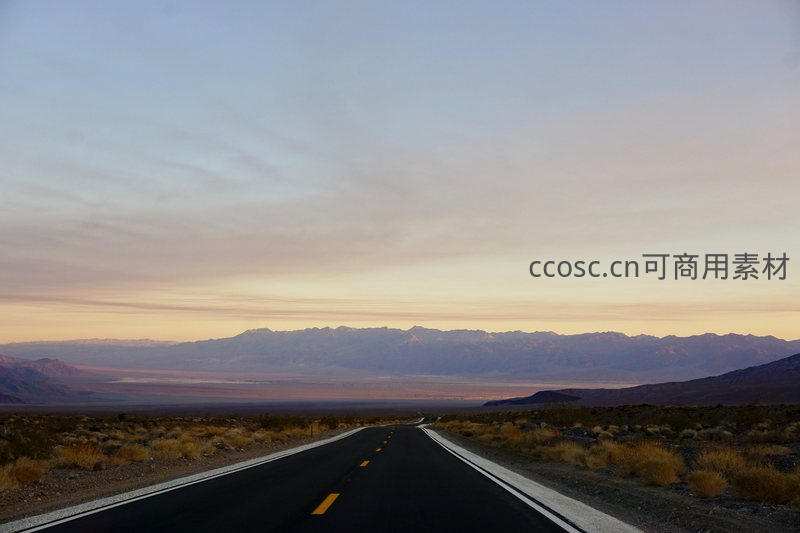 荒漠公路延伸至远方，落日余晖染金天际