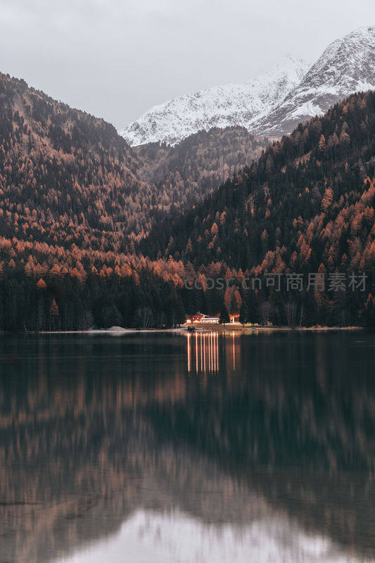 湖光山色映秋林，静谧小屋水中央