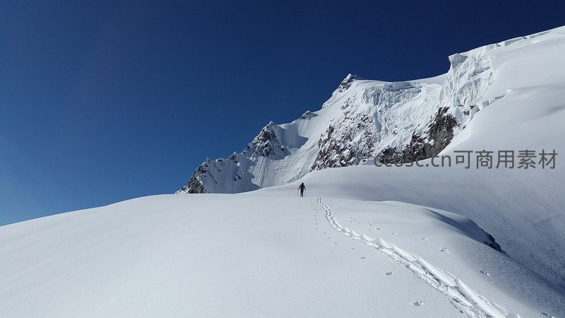 雪峰孤影：登山者踏雪前行