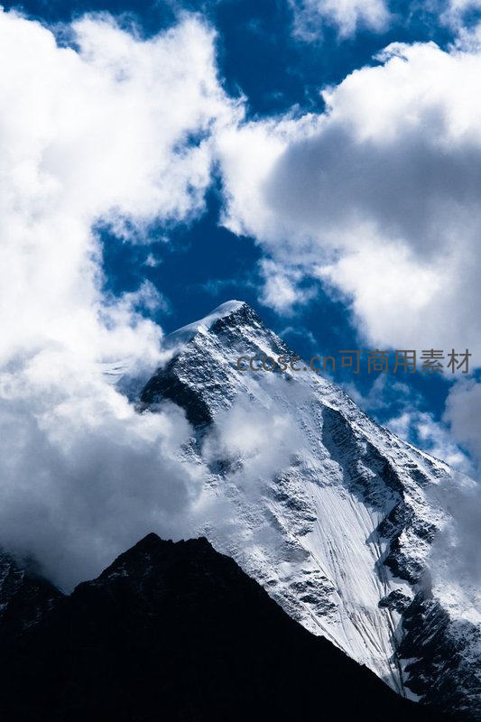 云海之巅：雪峰穿云破雾而出