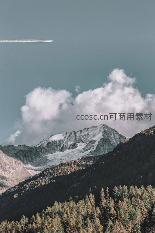 雪山森林上空飞机掠过