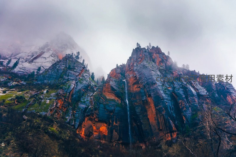 云雾缭绕山峰间，瀑布自峭壁飞流直下