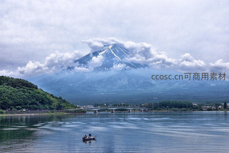 富士山云雾缭绕，湖面小舟点缀静谧山水画