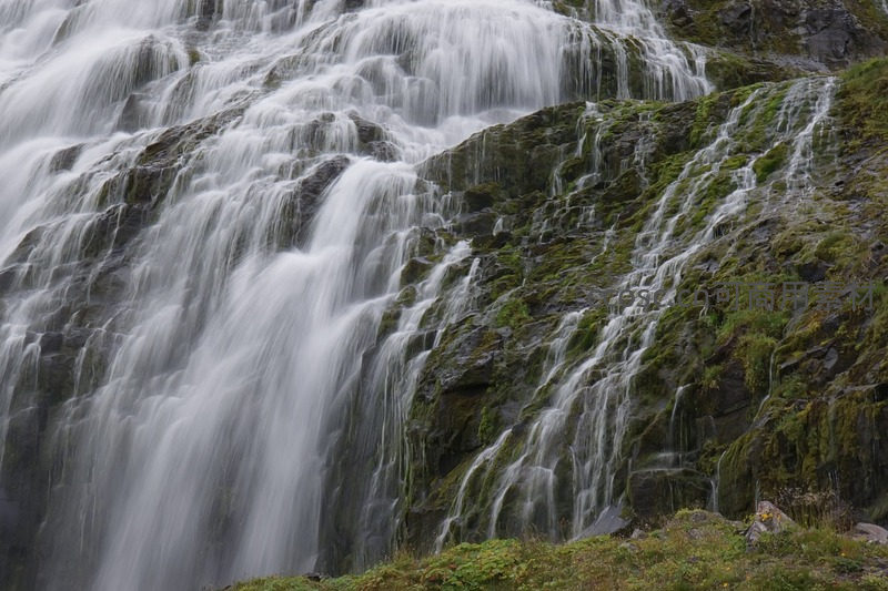 瀑布飞流直下，水雾弥漫青苔岩壁