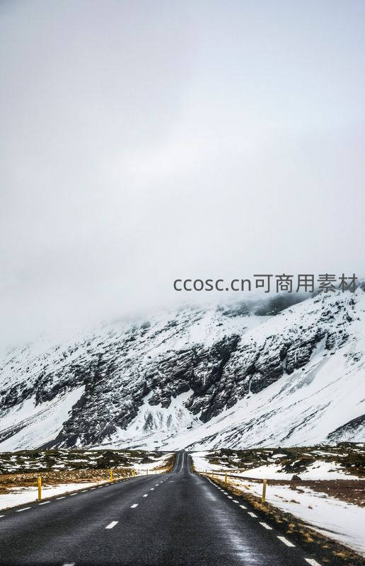 雪覆山峦间公路延伸，雾气弥漫营造神秘氛围
