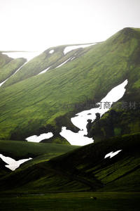 绿坡残雪似泼墨，山野苍翠蕴生机