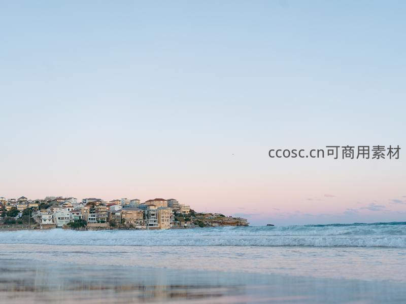 海滨小镇夕阳西下，浪花轻拍沙滩温柔