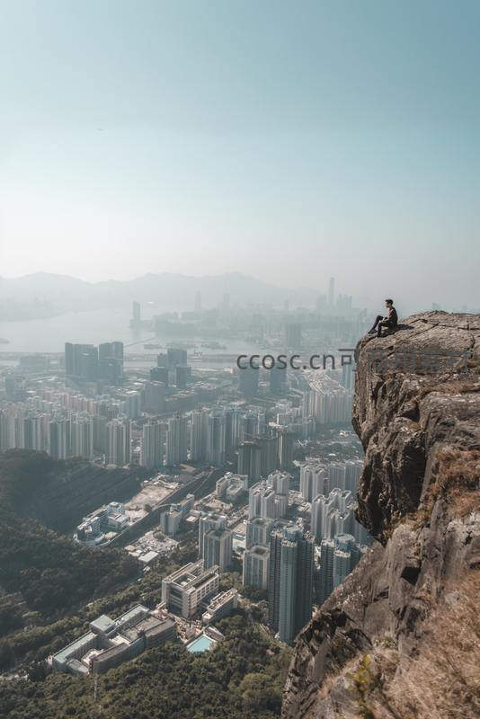 孤影坐崖边俯瞰繁华都市全景