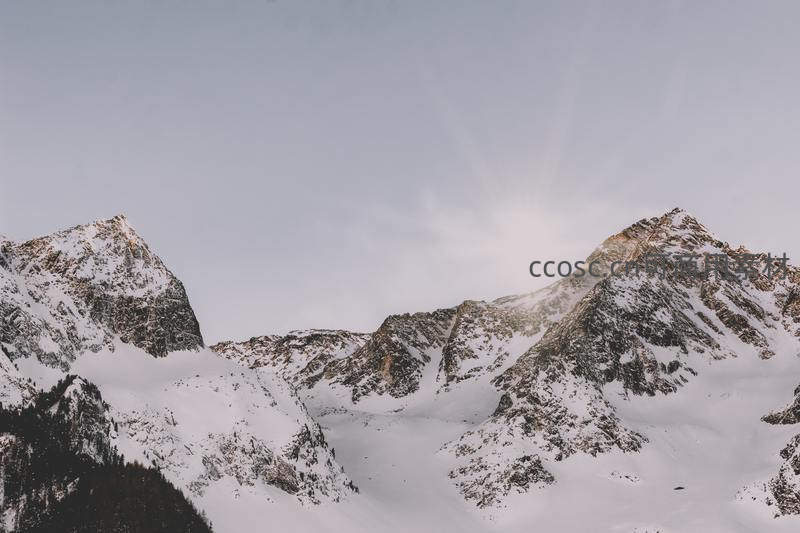 巍峨雪山之巅沐浴在晨曦微光中