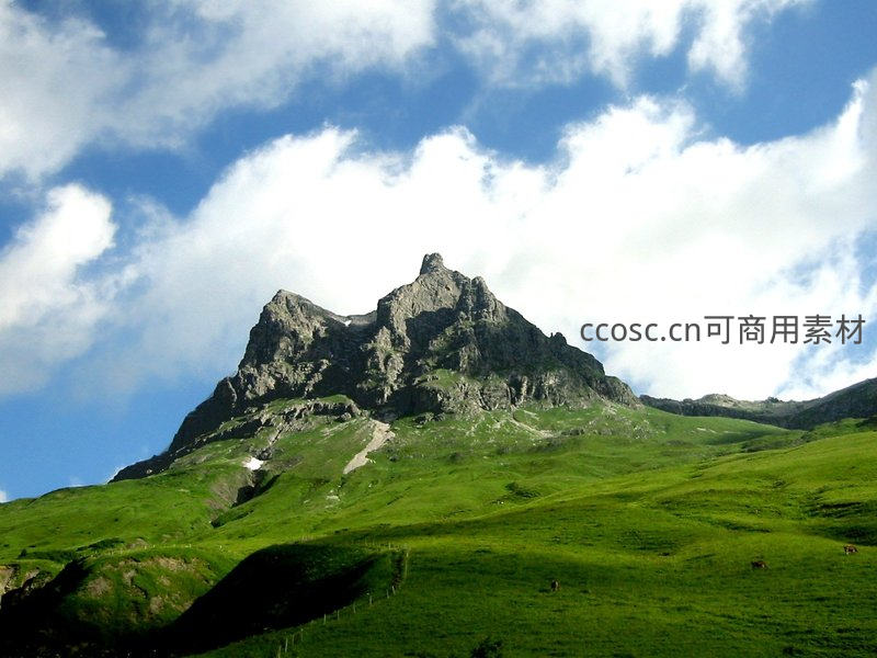 巍峨山峰耸立云端，绿野如茵映衬