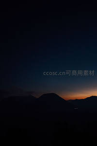 群山剪影下的橙红黎明破晓