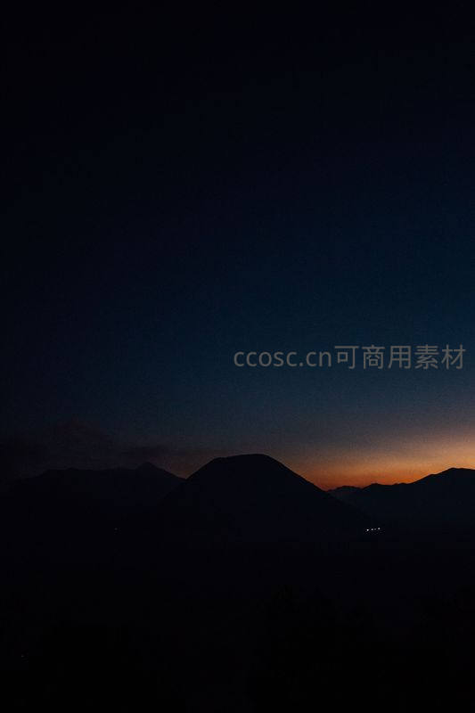 群山剪影下的橙红黎明破晓