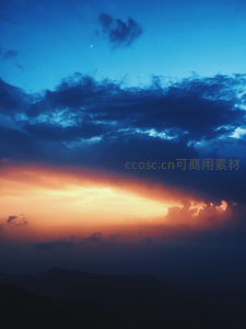 深蓝夜空下，新月与火烧云共舞