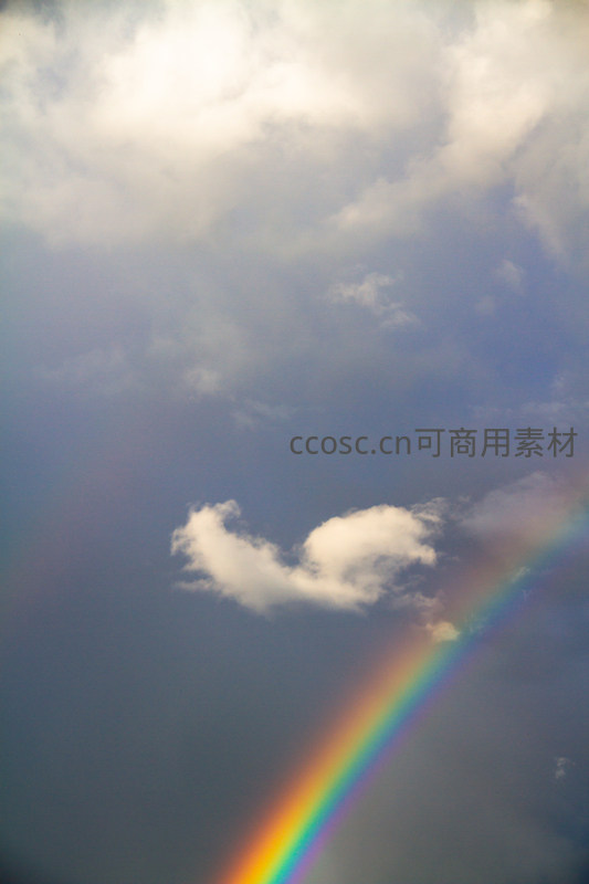 雨后彩虹横跨天际，洁白云朵点缀其间