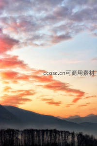 朝霞染红山峦与林间薄雾