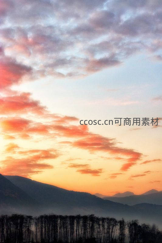 朝霞染红山峦与林间薄雾