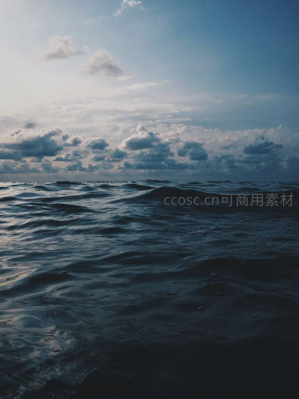 深邃海洋波涛起伏映衬多云天空