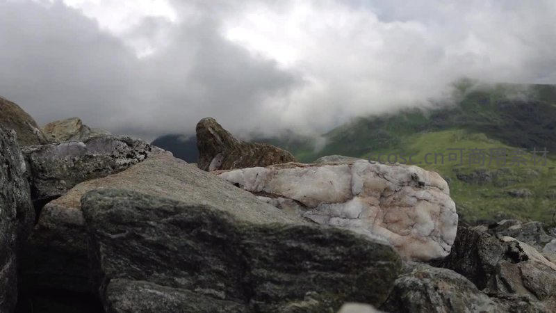云雾缭绕山峦间，巨石静卧显苍茫