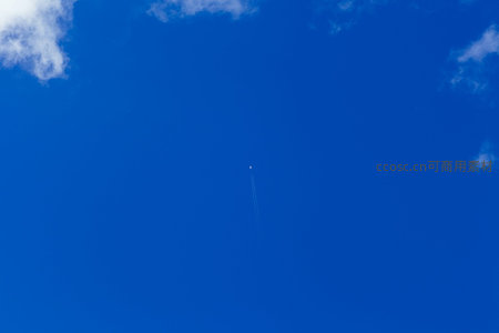 高空飞机划过蔚蓝天空留下白色尾迹