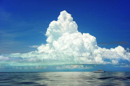 海上巨云如山峦，小舟静泊显渺小