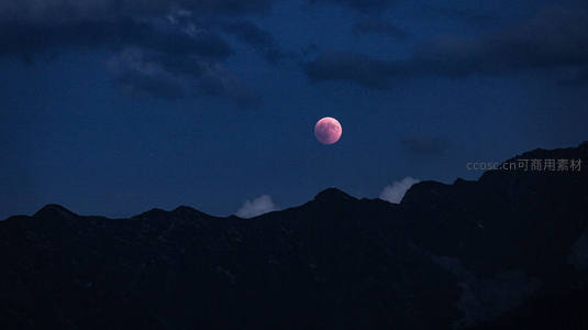 粉红月升雪山巅，夜幕低垂云轻绕