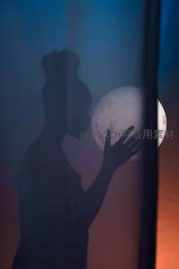 剪影女子轻抚月球，梦幻交织