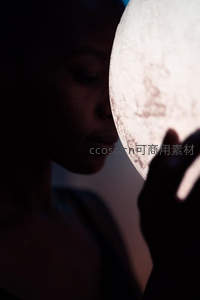 女子轻抚月球灯，光影温柔如梦