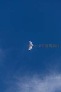 深蓝天空中的弯月与薄云
