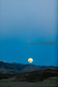 满月悬于山峦之上，夜空如洗