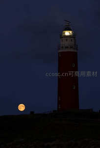 红灯塔旁圆月升起夜海景