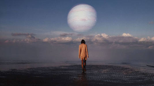 女子海边仰望巨大行星