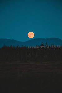 橙红满月升起，山林剪影如画