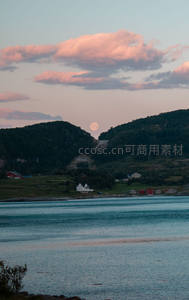 湖畔村庄静谧安详，满月从山峦间升起