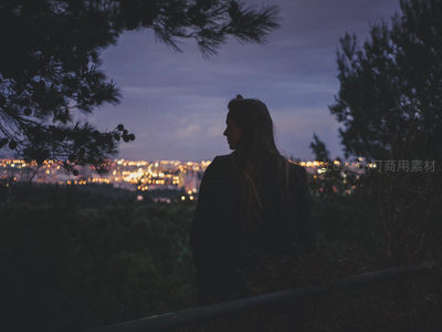 女子凝望灯火辉煌的城市夜景