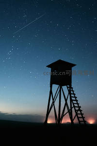 瞭望塔剪影下，流星划过繁星点点的夜空