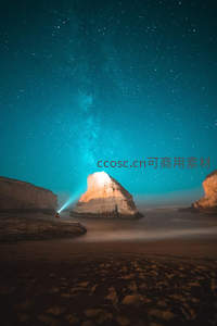 海岸巨岩旁手电照亮璀璨星海