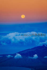 橙月悬云海，山巅风车舞长空