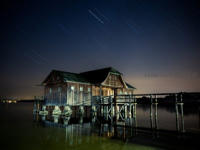 湖中木屋倒影与星轨共舞夜空