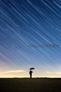 星轨下的孤独身影撑伞仰望夜空