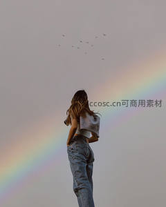 女子仰望彩虹，群鸟飞过暮色天际