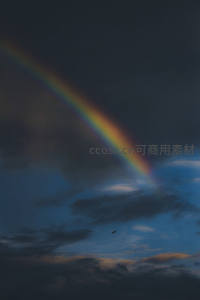 暗夜云层中斜挂的孤寂彩虹