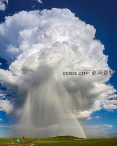 雷雨云下草原上的双彩虹