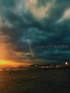 海滩黄昏云压顶，弧形彩虹贯长空