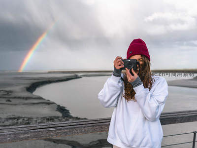 女孩海边拍摄彩虹雨后美景