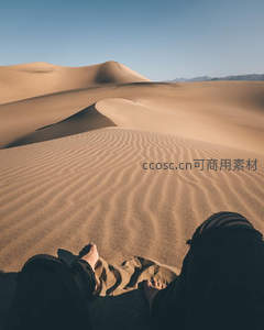 赤脚坐在沙丘上远眺风景