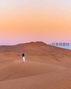 夕阳下的孤独旅人漫步沙海