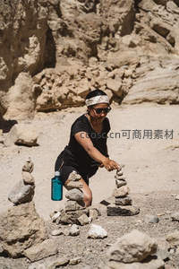 女子在岩石峡谷中堆叠石塔