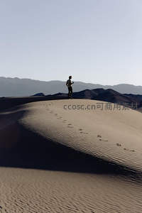 孤影立沙丘之巅，远眺群山